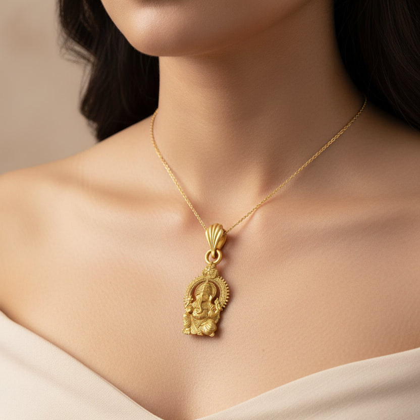 Gold pendant with a deity figure on a black background