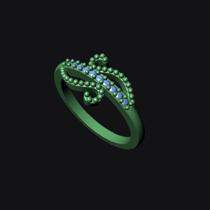 Green ring with small blue stones on a black background