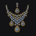 An ornate gold-toned jewelry set featuring a necklace and matching earring, both decorated with intricate filigree and large blue teardrop gemstones, set against a solid black background.