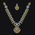 An ornate gold-toned traditional necklace set with matching pendant and earrings, featuring light blue stones and gold leaf-like detailing, displayed on a solid black background.