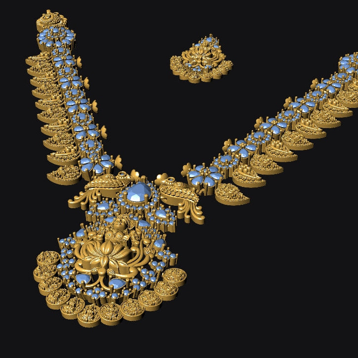 An ornate gold-toned jewelry set displayed on a black background, featuring a large pendant or brooch with a central blue gemstone and matching blue-studded decorative elements, plus a smaller matching piece above it.