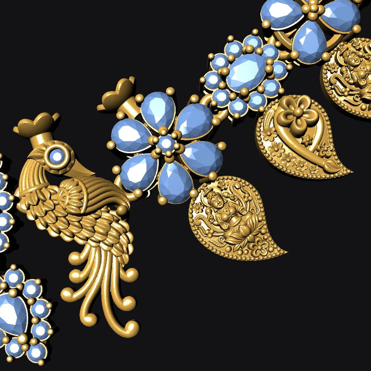 An ornate gold-toned jewelry piece featuring detailed bird motifs, floral clusters with light blue faceted stones, and paisley-style elements, arranged diagonally on a solid black background.