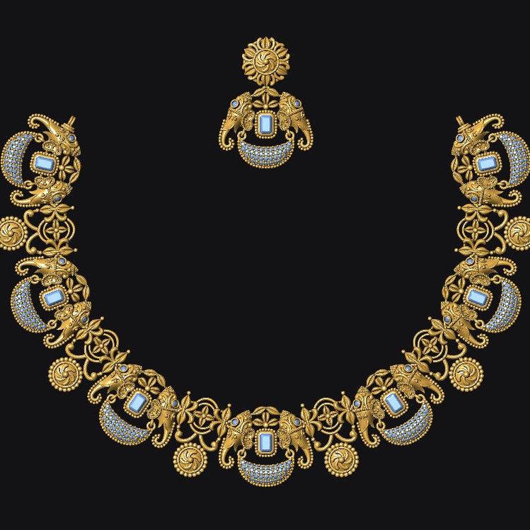 An ornate gold-toned jewelry set featuring a necklace and matching earring, decorated with intricate scrollwork, floral motifs, and oval blue-and-white stone inlays, displayed against a solid black background.