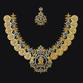 An ornate gold-toned traditional necklace set with a matching pendant, featuring circular coin-like motifs and small blue gemstone accents, displayed on a solid black background.
