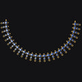 A gold crescent-shaped necklace with blue teardrop-shaped gemstones, displayed against a solid black background.