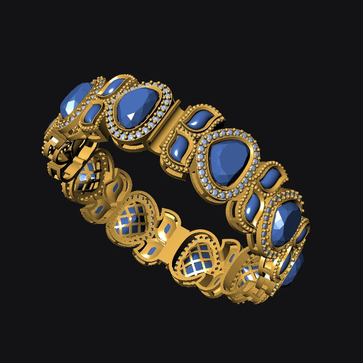 A gold-toned ornate bracelet featuring large blue teardrop-shaped gemstones and small clear stones, shown on a solid black background.