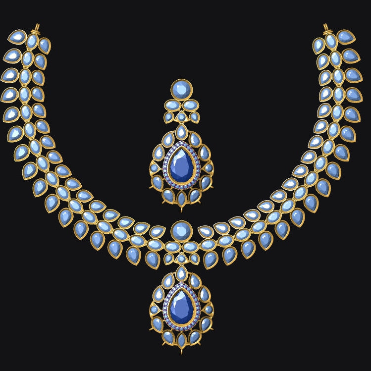 Gold-toned traditional Indian jewelry set featuring a necklace and matching pendant, embellished with white stones and blue teardrop gemstones, displayed on a solid black background.