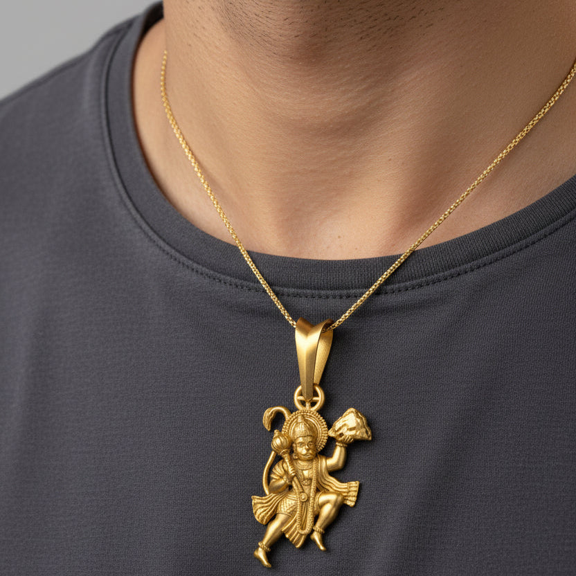 Gold pendant with a deity figure on a black background